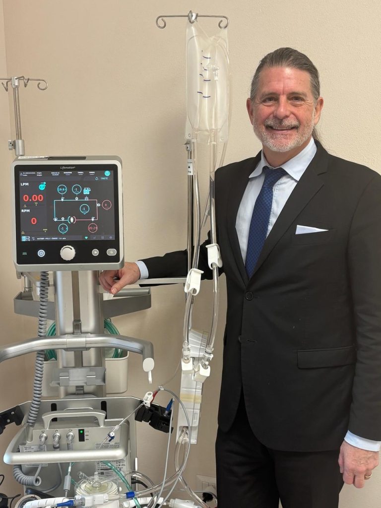 Portrait of Michael Van Driel next to the ECMO machine,
